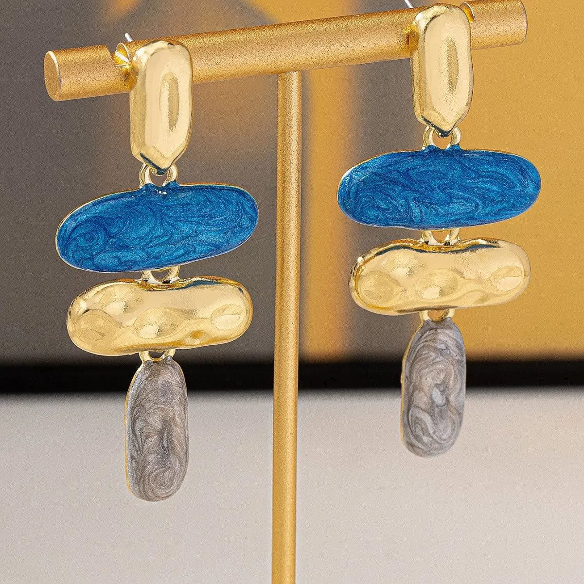 A pair of simple geometric stud earrings with a multicolour metallic electroplated finish.