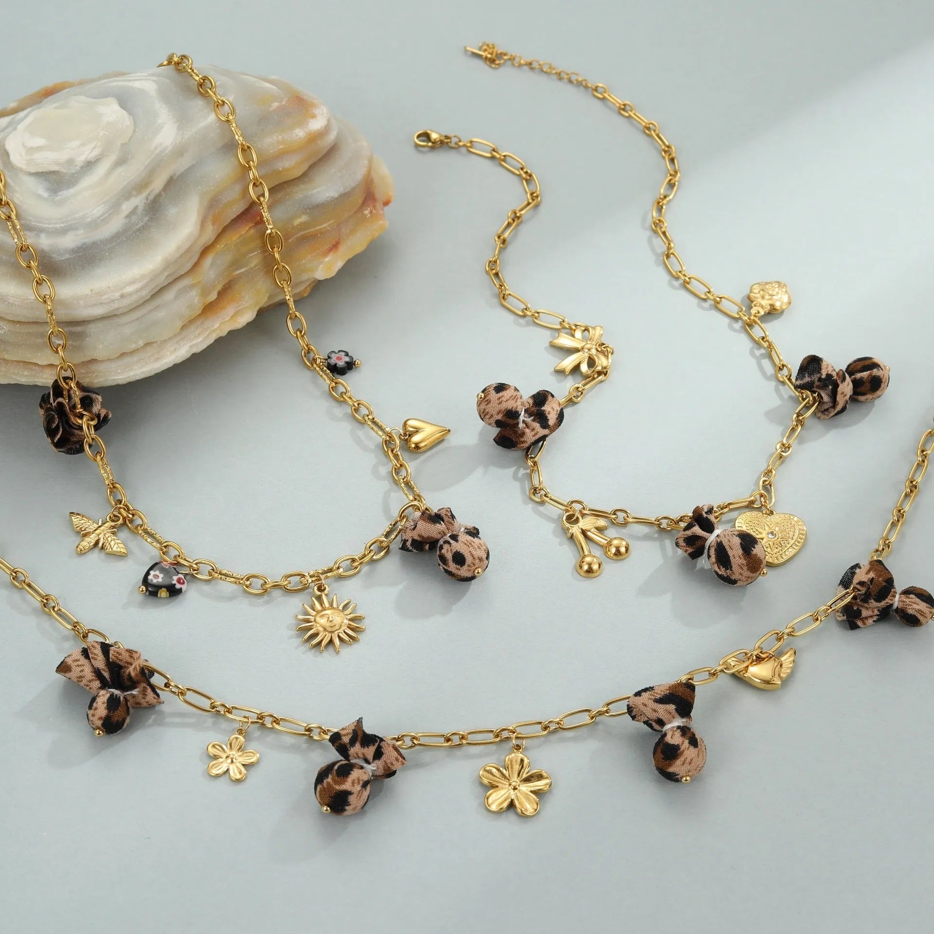 Geometric stainless steel necklace with leopard, heart and flower motifs on 18K electroplated pendant
