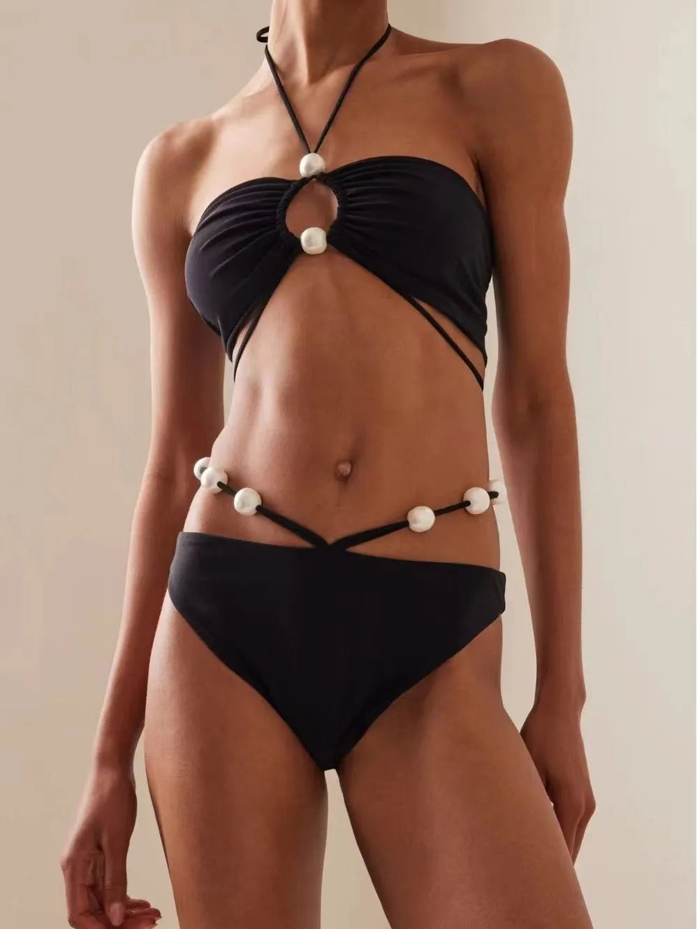 Women's split lace-up bikini swimsuit in black, two-piece set with bra and shorts on plain background