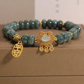 Close-up of a women's bracelet with green emerald jade abacus beads and a metallic alloy safety lock clasp.