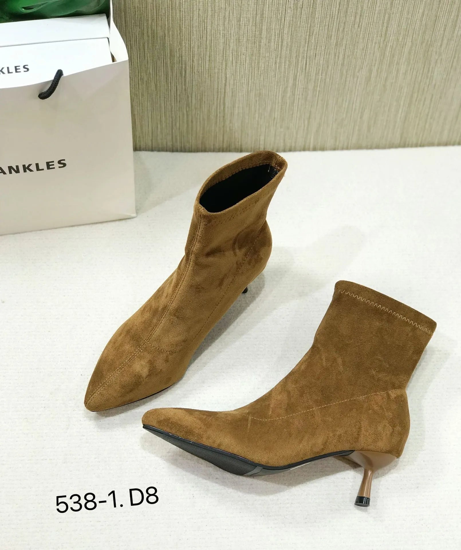 Black pointed toe ankle boots with a stiletto heel on a white background