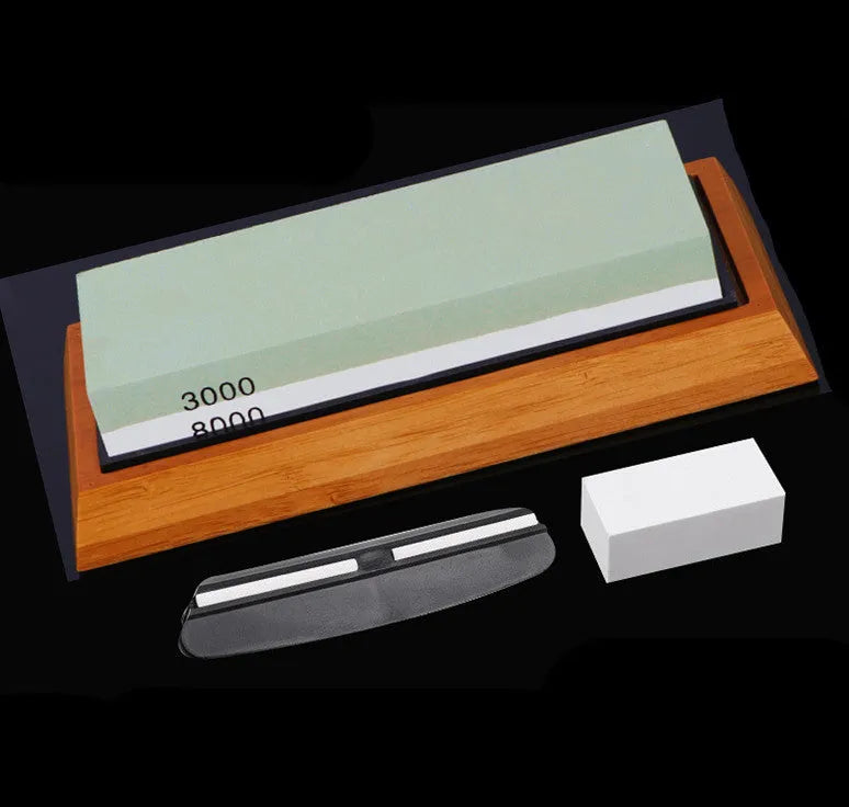 Double-sided white corundum kitchen whetstone 3000/8000 grit with bamboo base and knife holder locator on white background