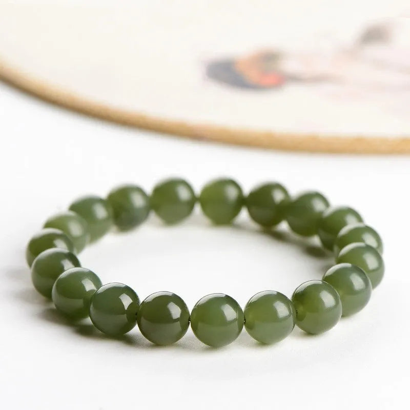 Polished Hetian jade ball bracelet in ice-like clear water colour on a wrist, showing bead detail.