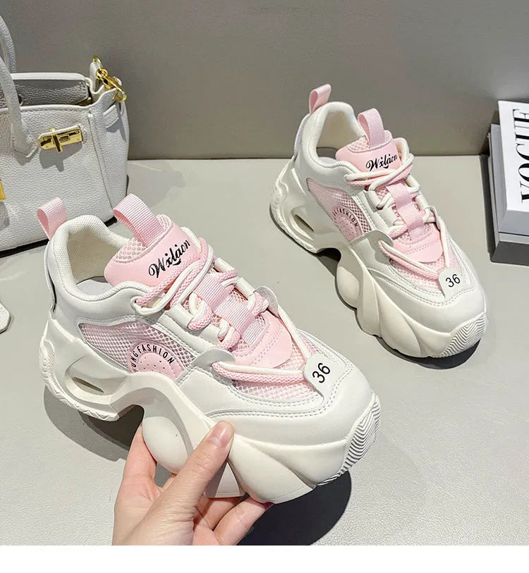 Women's pink sneakers with cross shoulder straps, thick platform sole, and breathable mesh lining.