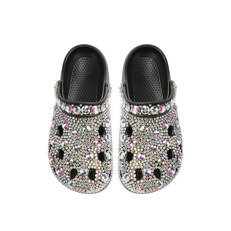 Black platform sandals for women with rhinestone decoration and a hole design upper on a white background.