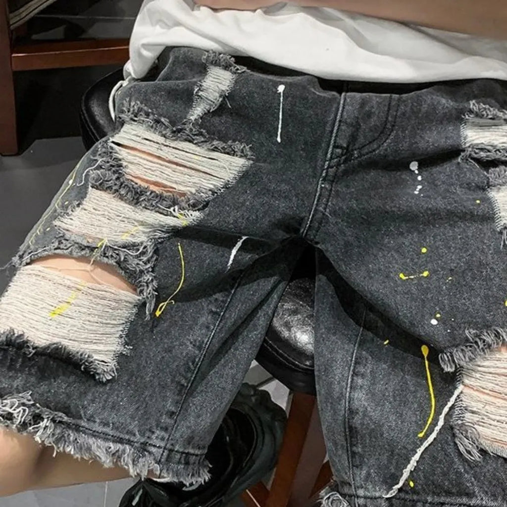 Men's loose fit denim shorts in light blue with water washed hole detail, laid flat.