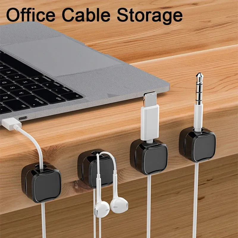 Magnetic cable clip in white holding a USB cable under a desk, with adhesive backing visible