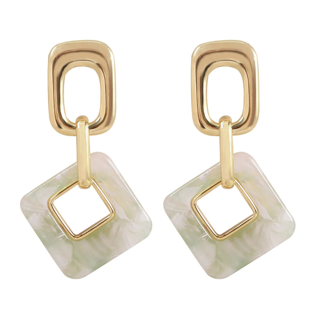 Dignified hollow geometric square copper earrings with electroplated finish on white background
