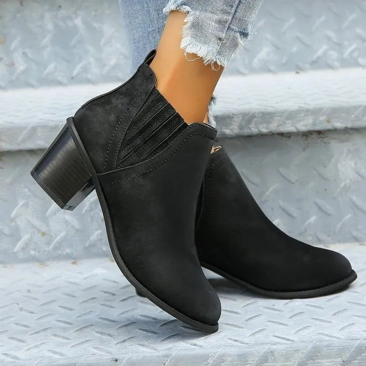 Black women's pointed toe ankle boots with a thick square low heel and slip-on design.