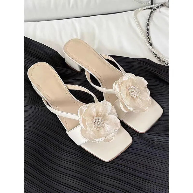 Women's chunky heel sandals with square toe, satin upper, and floral detail in cream-white.