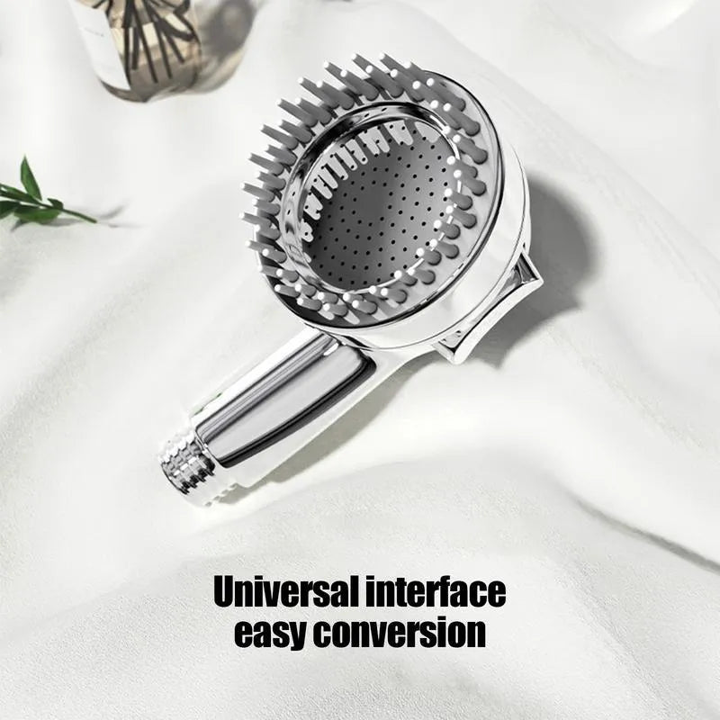 Silver dog shower attachment with soft silicone comb teeth and ergonomic grip on a white background