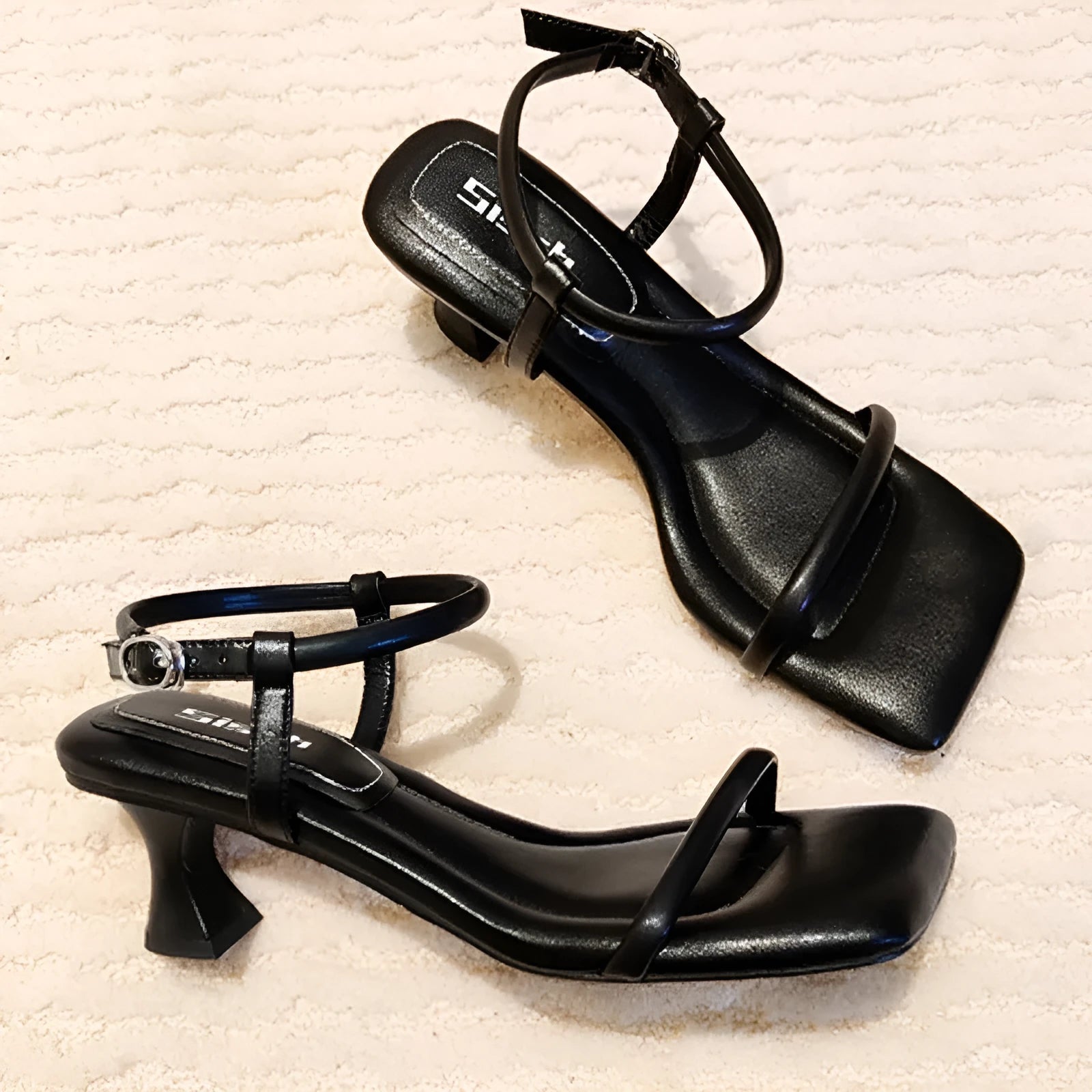 Black square toe high heel sandals with thick heel and one-line buckle strap on a white background