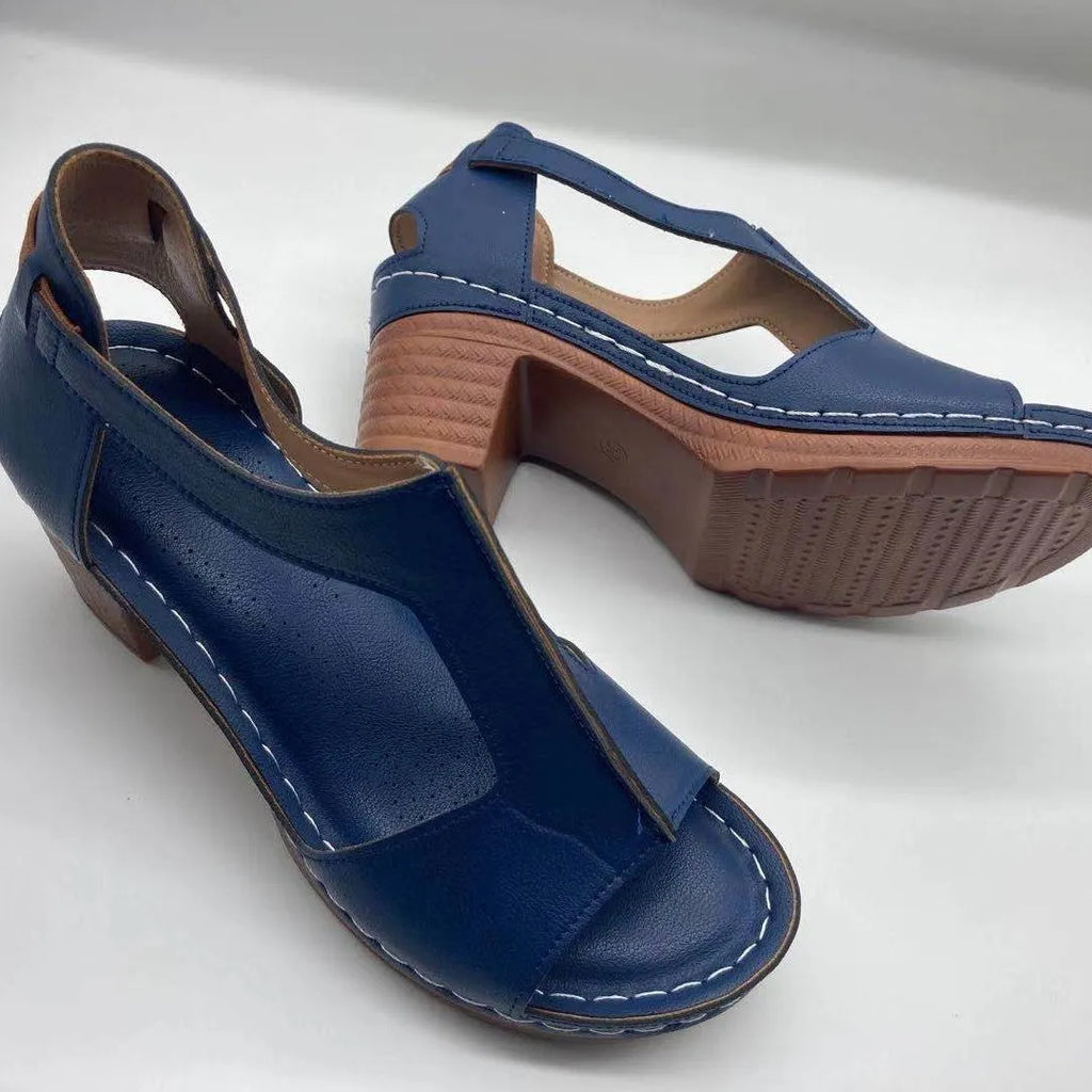 Women's beige peep toe wedge sandals with Roman ankle straps and a buckle closure on a low heel.