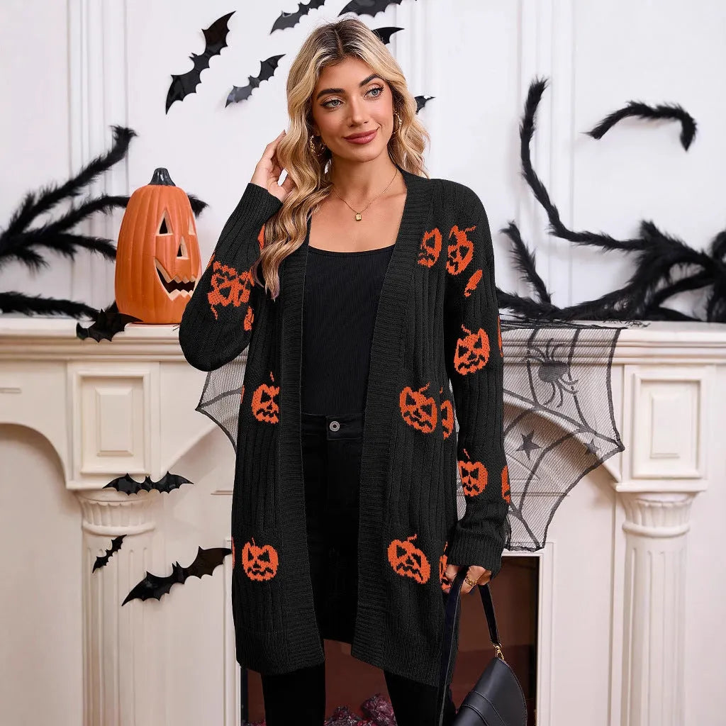 Women's black Halloween cardigan with jacquard-knitted orange pumpkin head pattern, shown as a straight-cut medium-length coat.