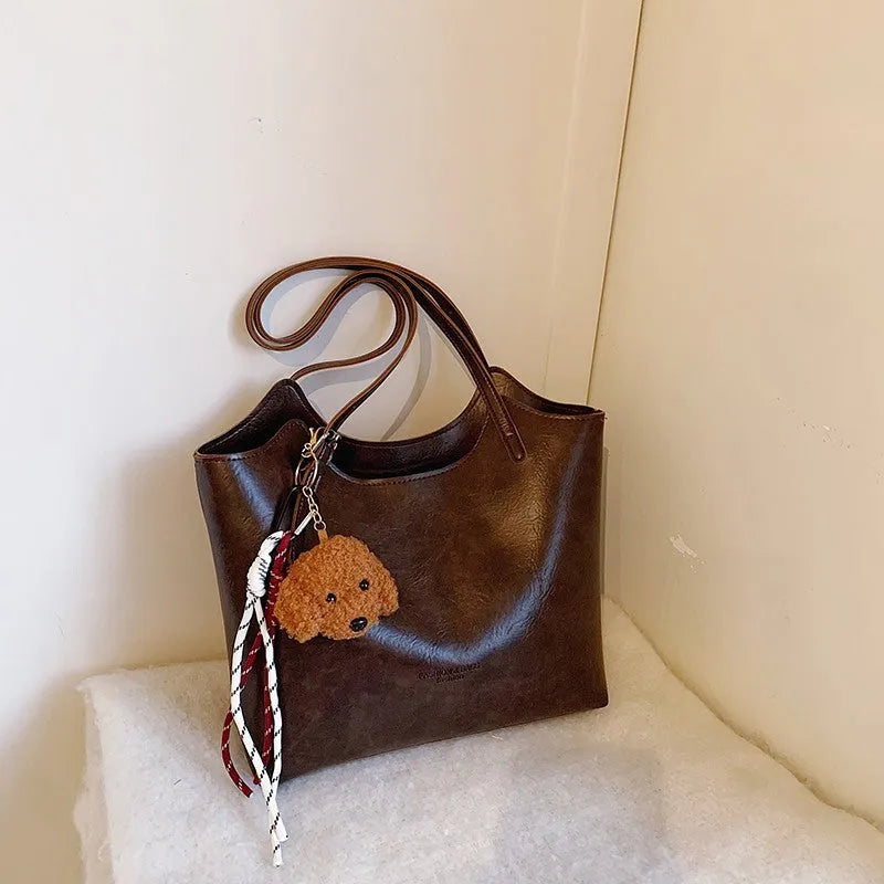 Women's PU commuter shoulder bag in black with stitching details and optional ribbon pendant, horizontal square shape