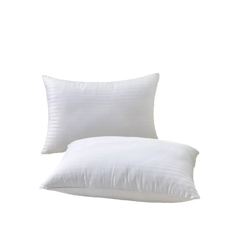 White cotton satin stripe pillow with feather and cotton filling shown in adult bedding setting.