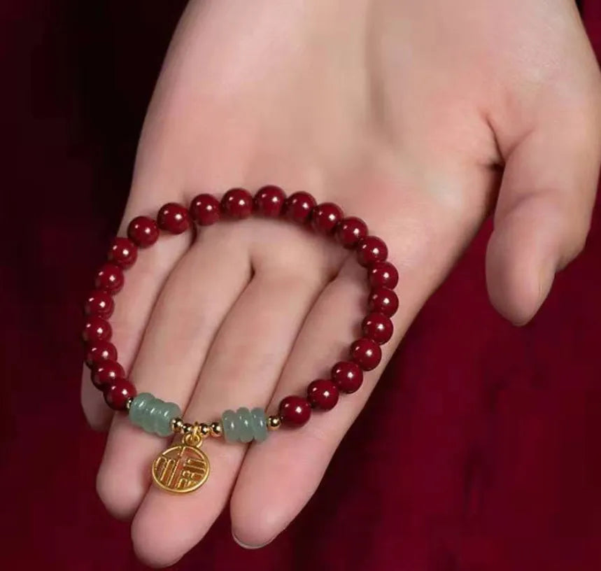 Handmade wave-shaped bracelet featuring cinnabar and copper beads on a wrist.