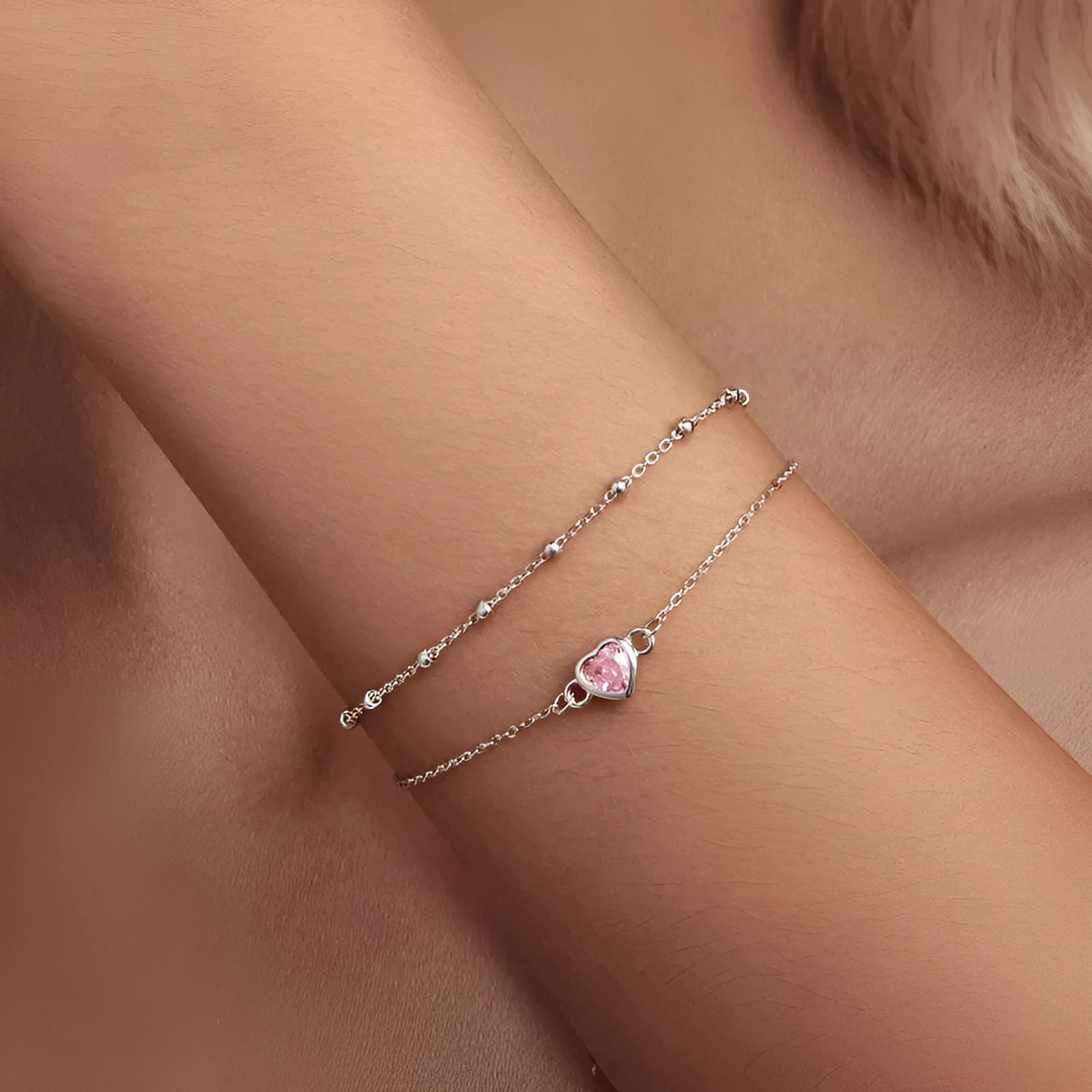 Sweet girlish heart-shaped sterling silver bracelet with adjustable chain on a white background.