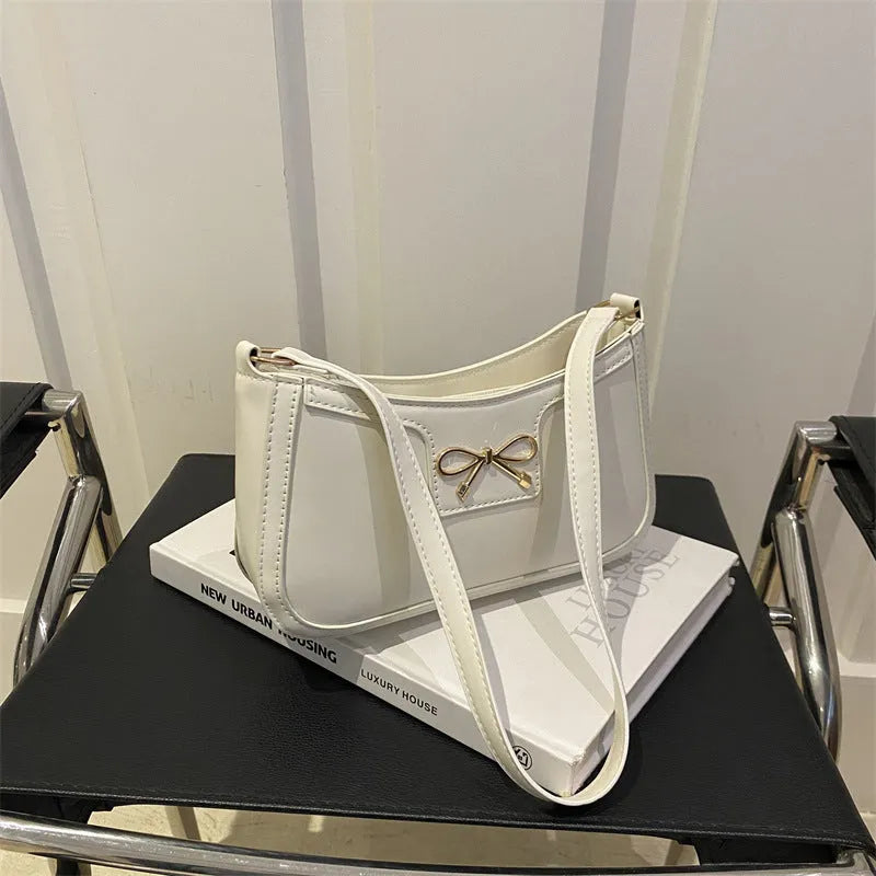 PU leather baguette bag with bow decoration in rose red colour, 24x14x5 cm size on white background