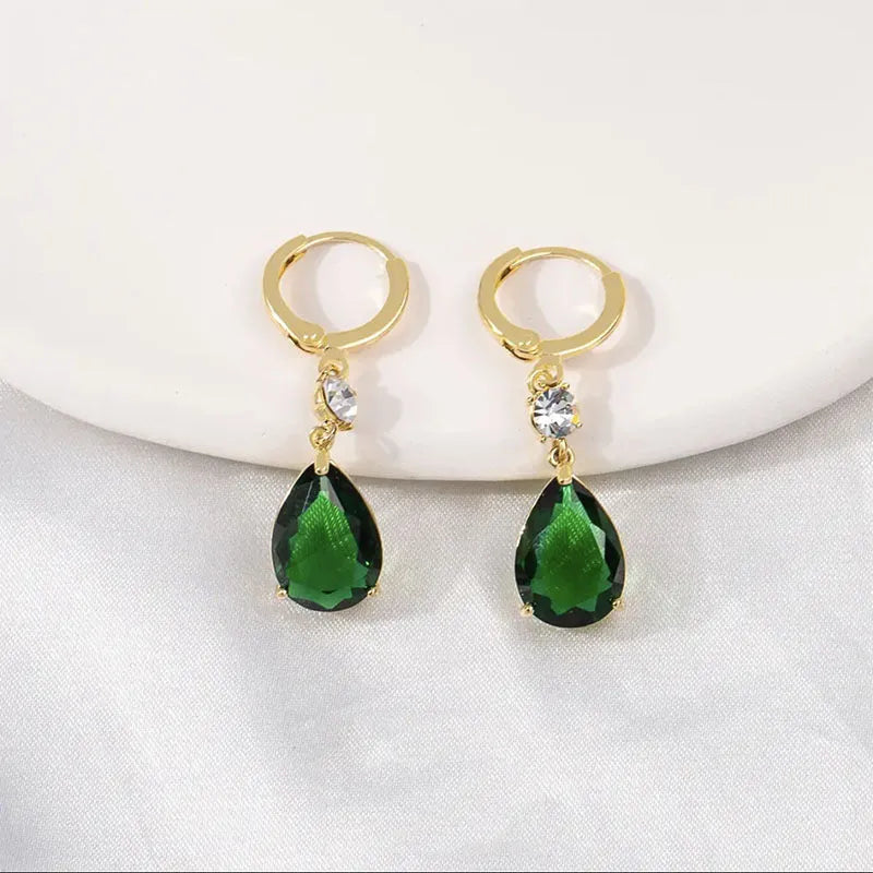 Green geometric teardrop alloy earrings with post findings on plain background
