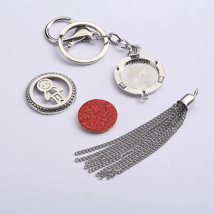 Silver alloy tassel aromatherapy car pendant with long chain on a coloured background.