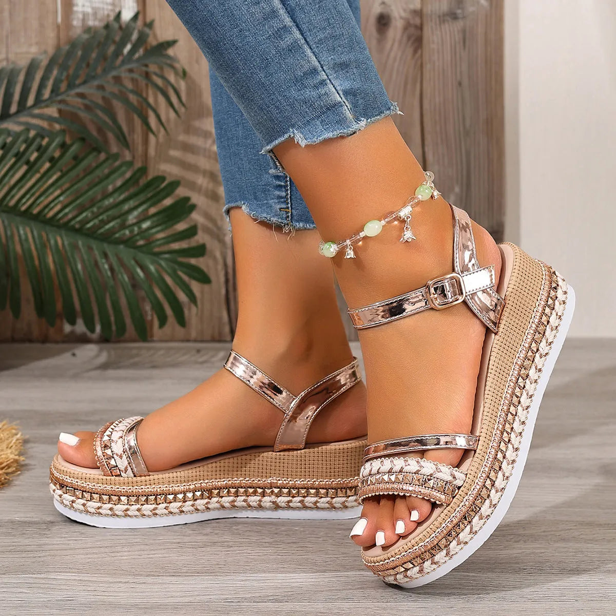 Women's woven wedge sandals in gold with round toe and PU upper, side view on neutral background