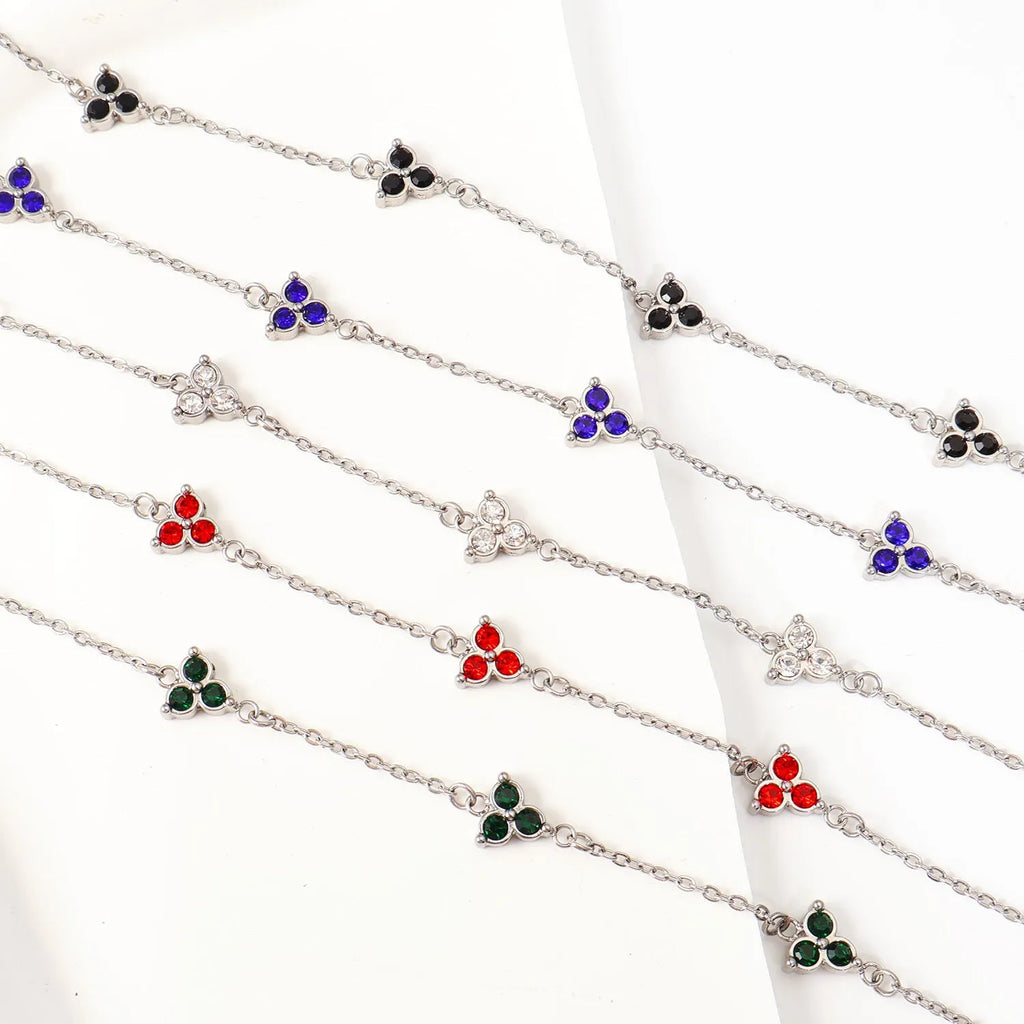 Geometric stainless steel women's bracelet with three diamond shapes and coloured stone settings.