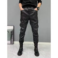Black PU leather motorcycle takeaway pants with cuffs, tapered leg, and mid-rise waist, on a model
