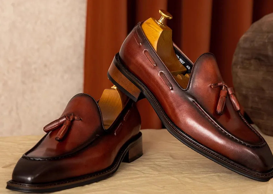 Men's black leather slip-on loafers with fringed detail and rubber sole