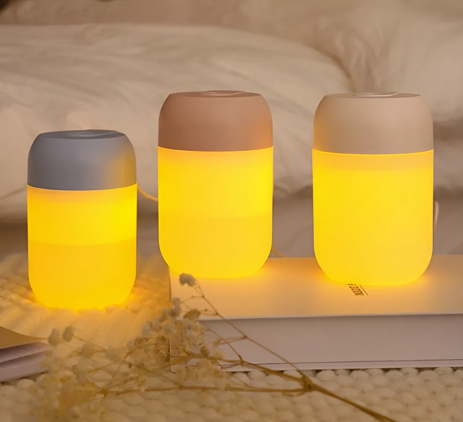 White cylindrical USB mini humidifier with charging cable on desk