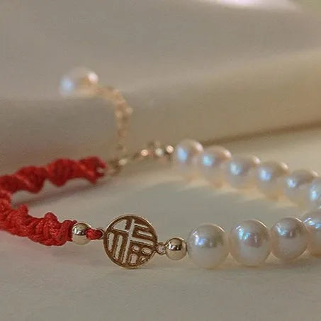 Women's pearl braided red rope bracelet with domestic 14K gold plated fu character charm on red background
