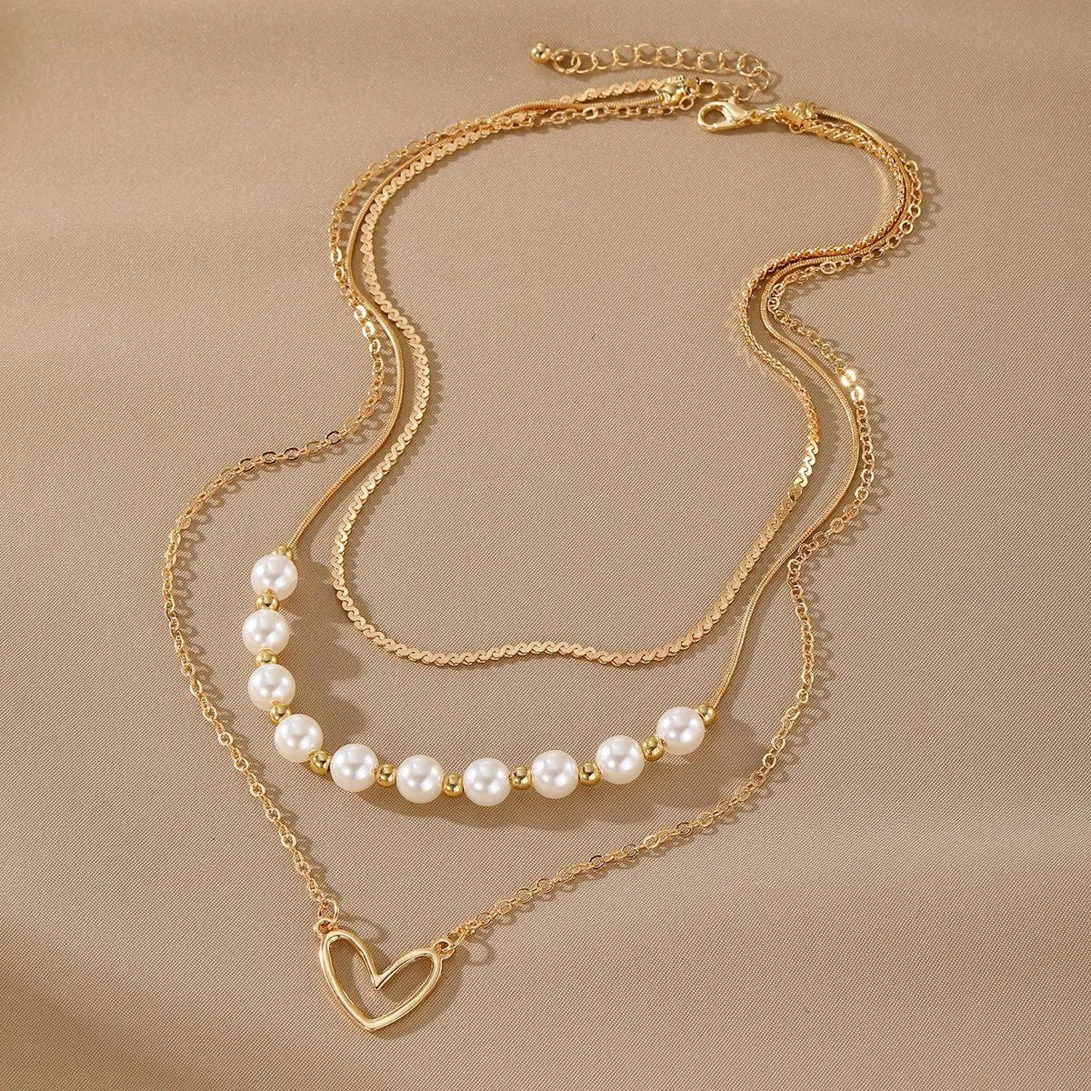 Vintage gold necklace with heart pendant on pearl chain showing adjustable length mechanism