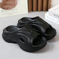 Women's thick-soled EVA slippers in rose red, white and black colours on a beach background.
