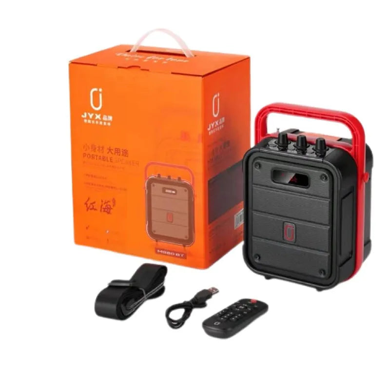 MS62AI portable Bluetooth speaker with wireless microphone on a table, showing remote control and charging cable.
