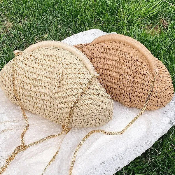 Women's beige straw shoulder bag with chain detail and a zippered interior.
