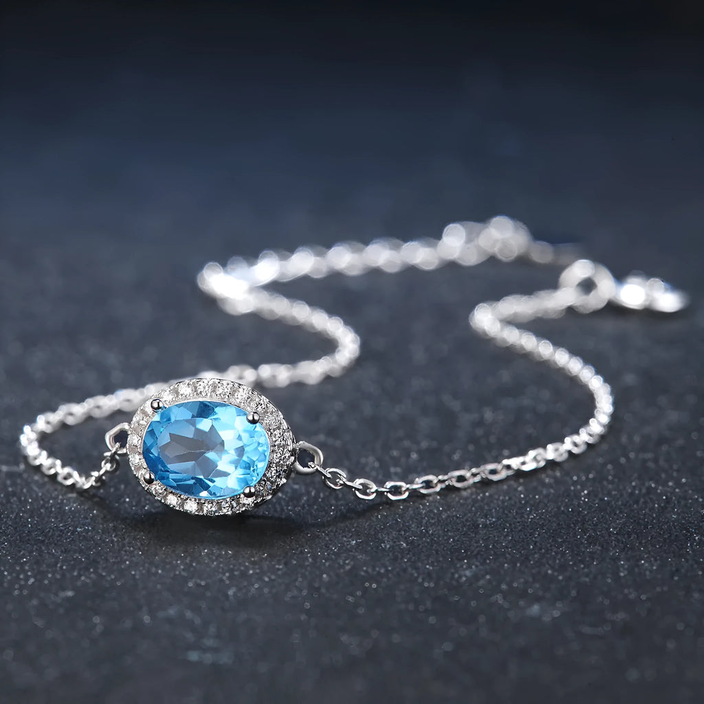925 sterling silver jewellery set with blue topaz gems showing earrings, ring, pendant, and necklace with geometric design