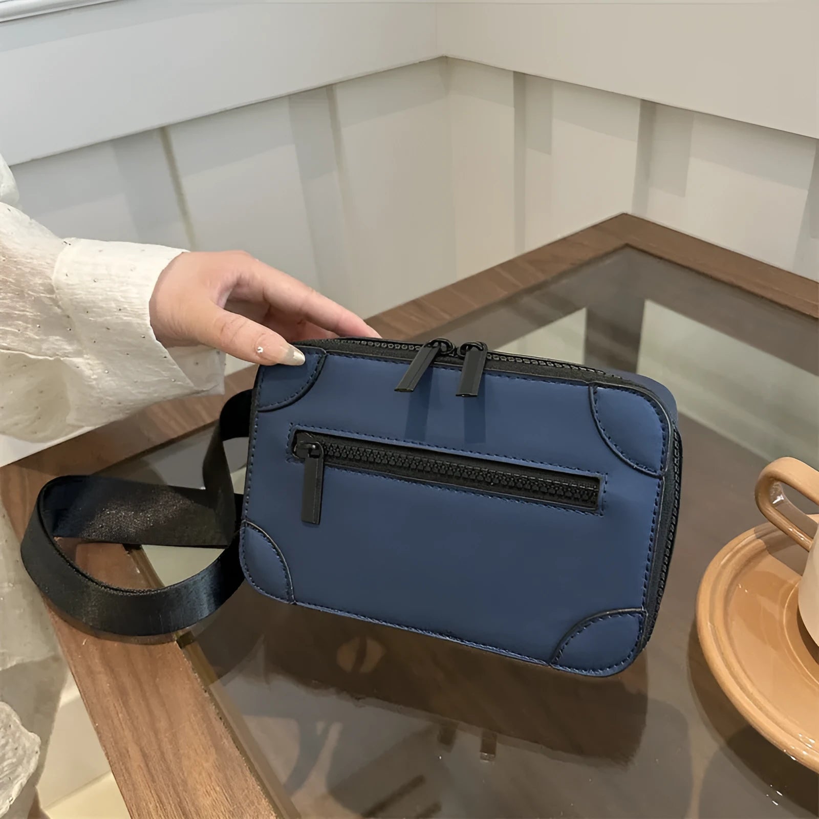 Women's small square PU crossbody bag in black with sewing line detail, single shoulder strap, and external pocket