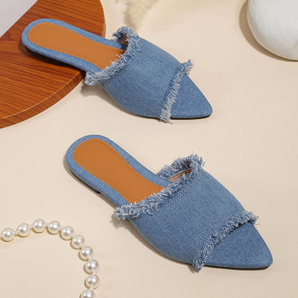 Women's denim flat slippers with tassel detail and leather lining in multiple colour options.