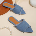 Women's denim flat slippers with tassel detail and leather lining in multiple colour options.