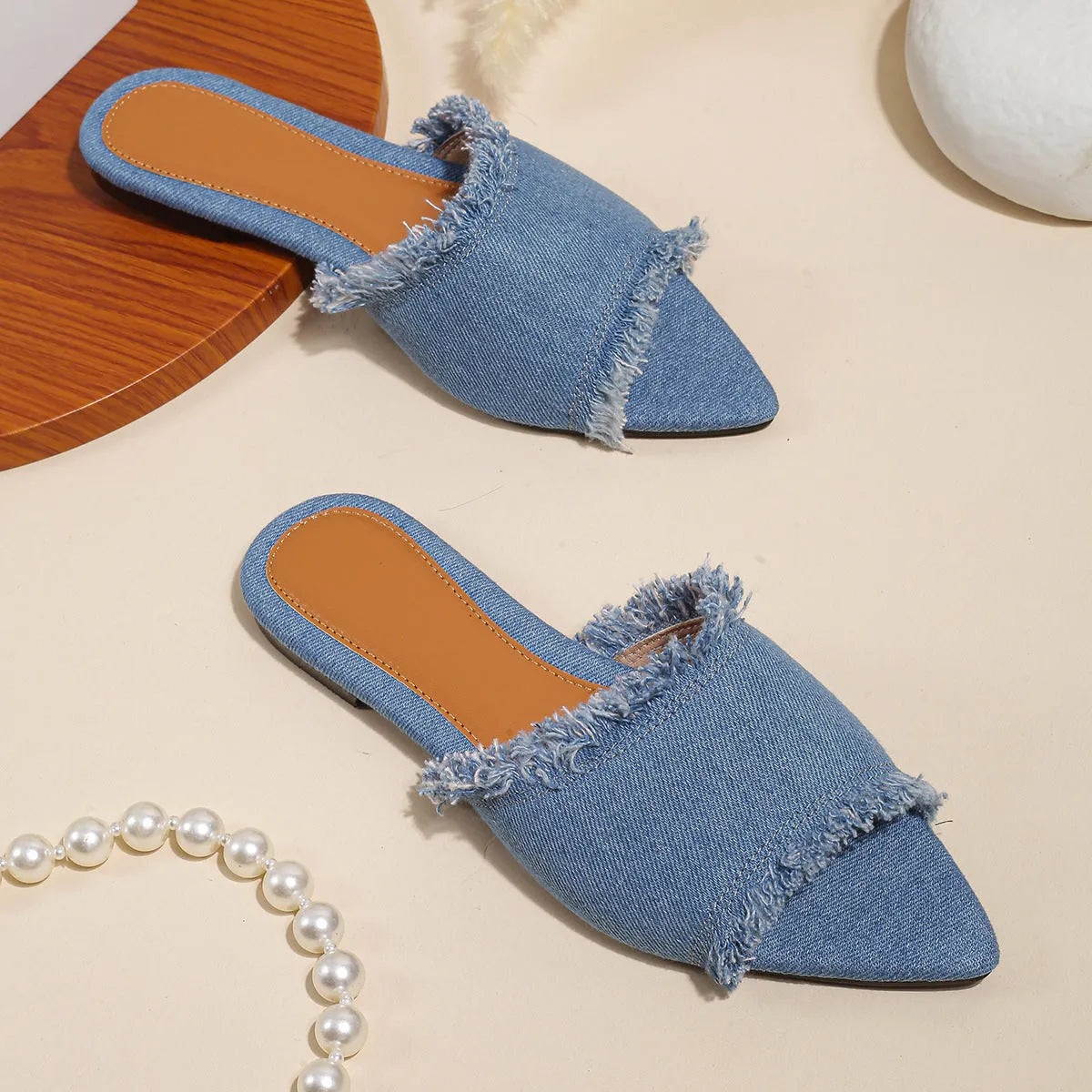 Women's denim flat slippers with tassel detail and leather lining in multiple colour options.