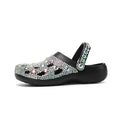 Black platform sandals for women with rhinestone decoration and a hole design upper on a white background.