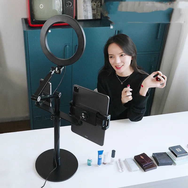 Black aluminium alloy and ABS mobile phone tablet stand with built-in fill light, folded vertical orientation on a table