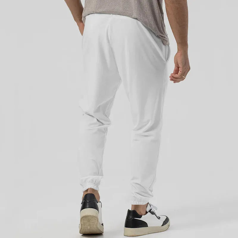 Men's gray loose fit tapered casual sweatpants with elastic waistband on a neutral background.