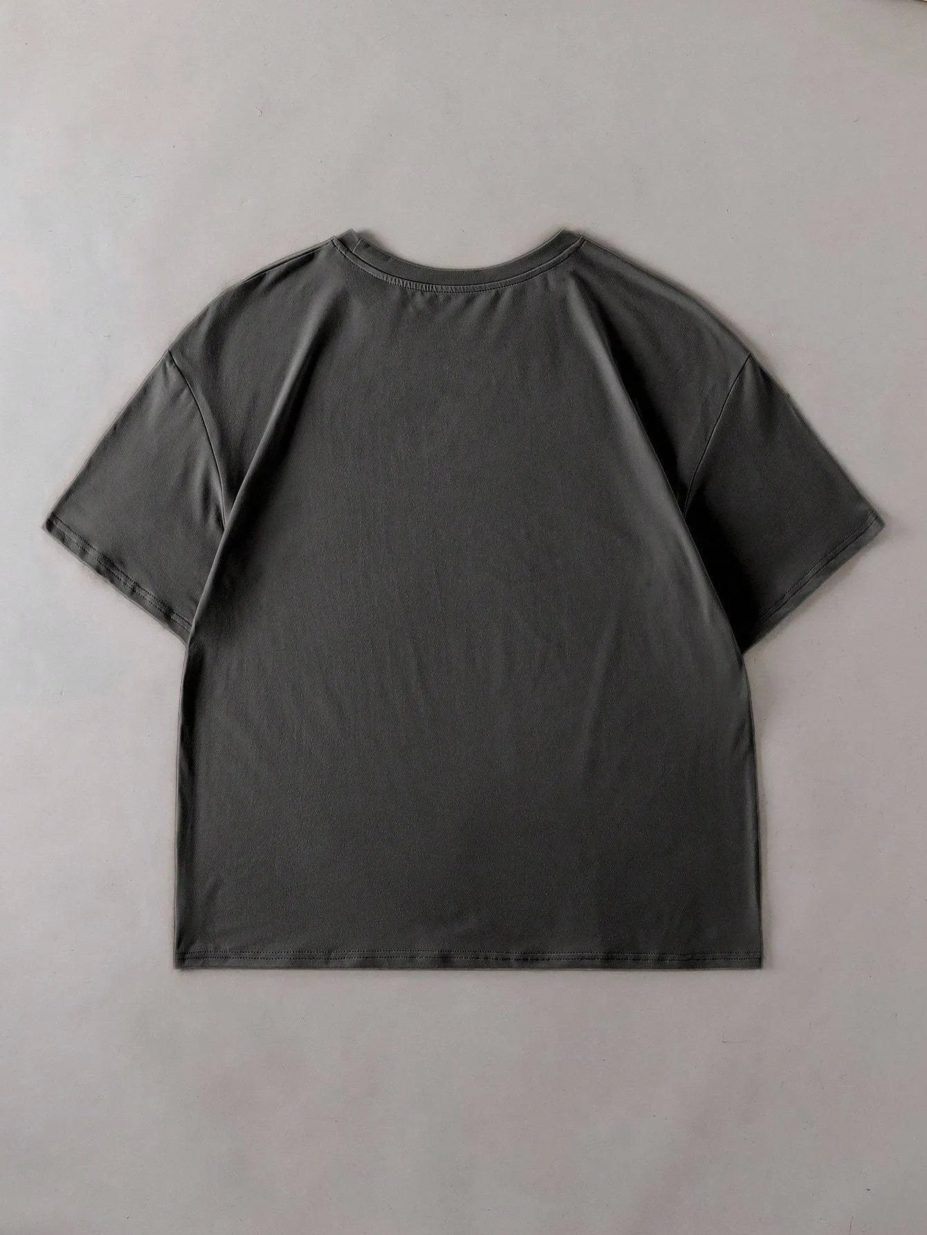 Loose fit short sleeve cotton t-shirt in black on a hanger, showing round neck collar.