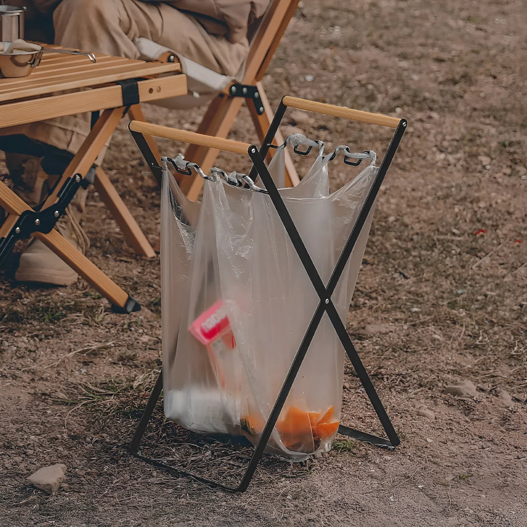 Outdoor folding garbage storage hanger with wrought iron frame and wooden handle.