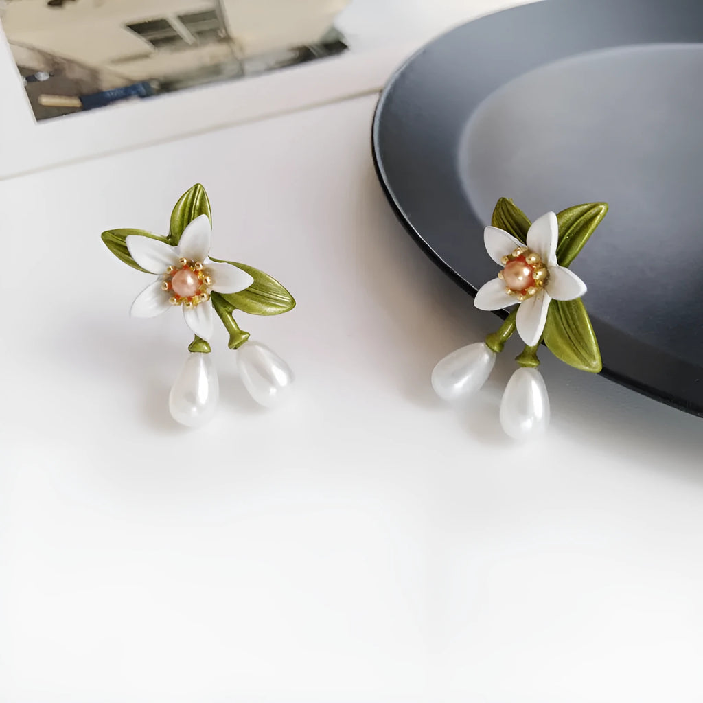 Silver colour needle camellia flower earrings showing stud and clip-on styles.