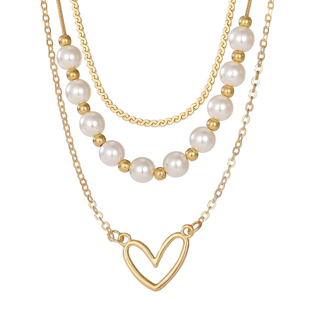 Vintage gold necklace with heart pendant on pearl chain showing adjustable length mechanism