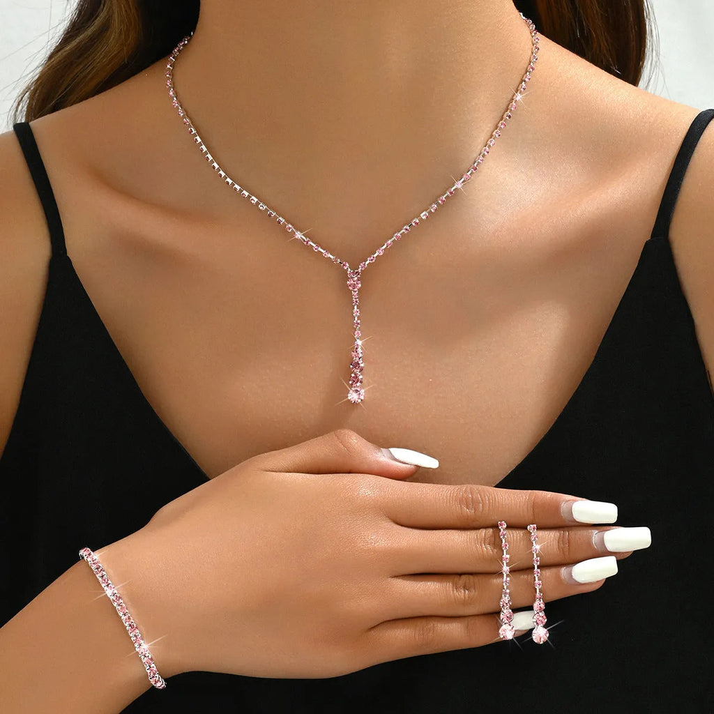 Rhinestone bridal jewellery set includes necklace, bracelet, and earrings in silver with tassel and heart elements