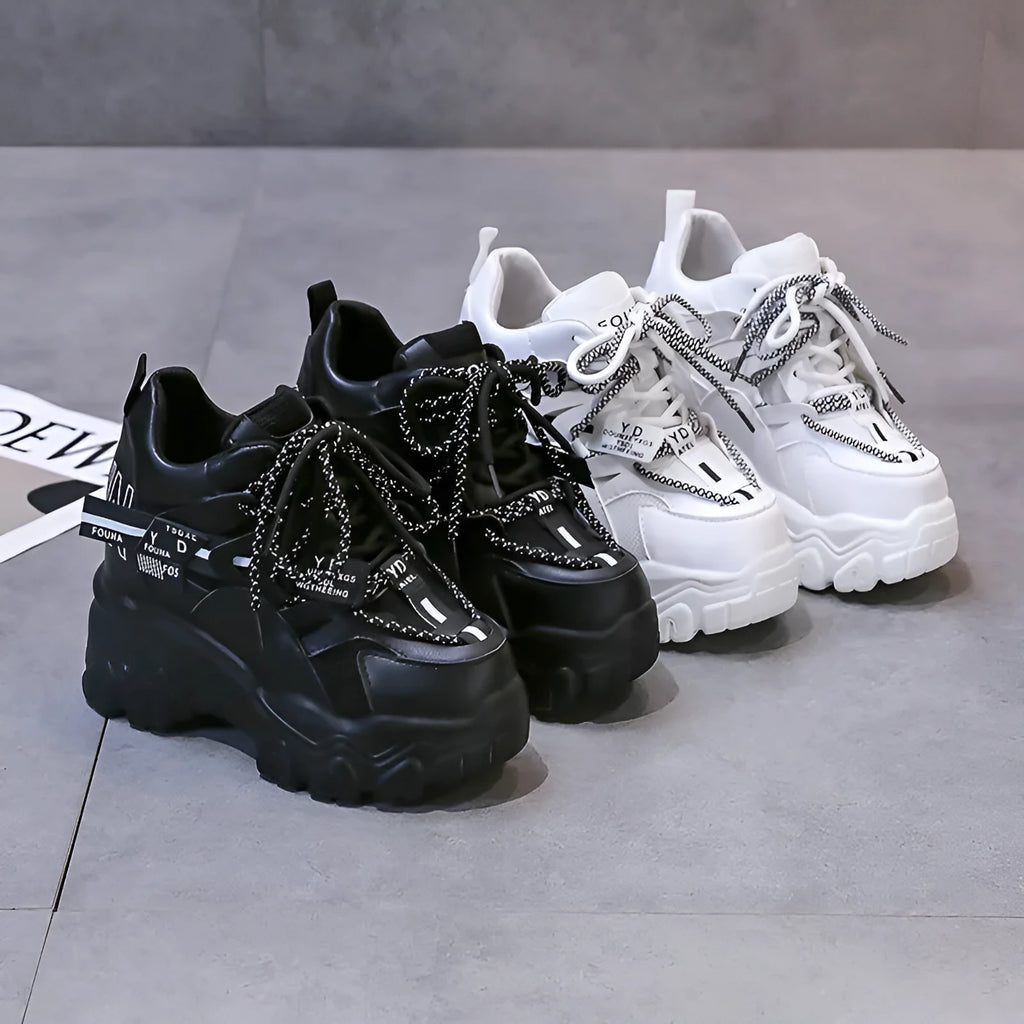 White and black women's low-top platform sports shoes with mesh upper and cross strap.