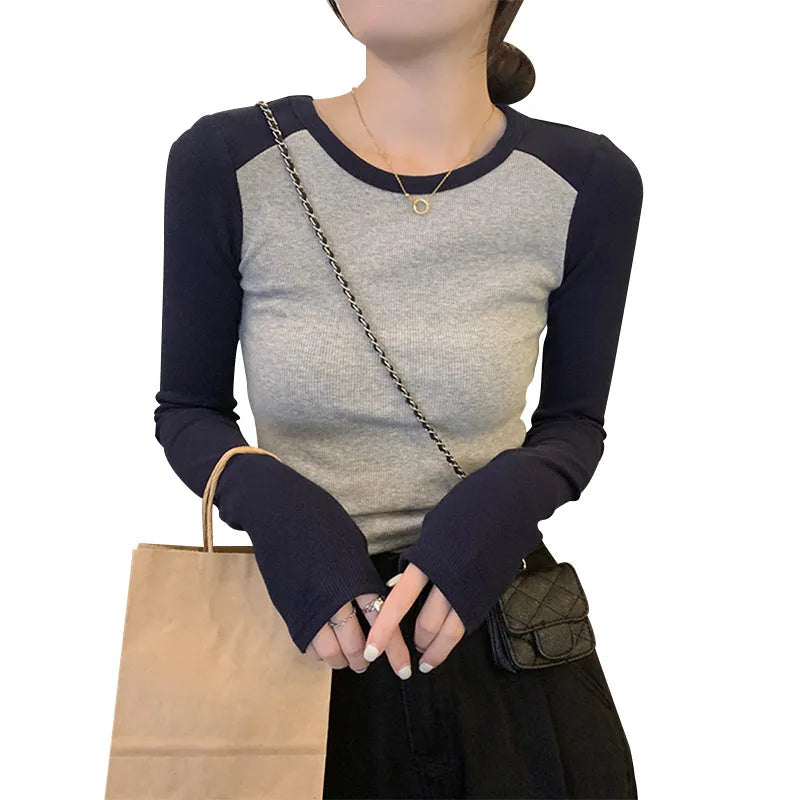 Dark blue oversized women's casual top with long princess sleeves and embroidery detail on a hanger.